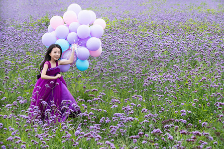天真摄影照片_拿着气球的小女孩在花海里奔跑