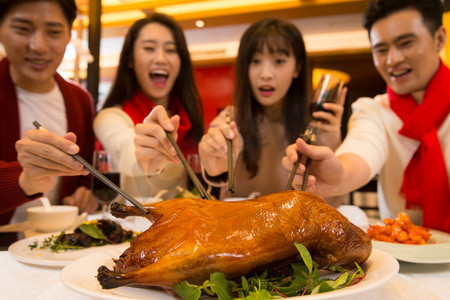 烤鸭美食摄影照片_青年人在餐厅聚餐