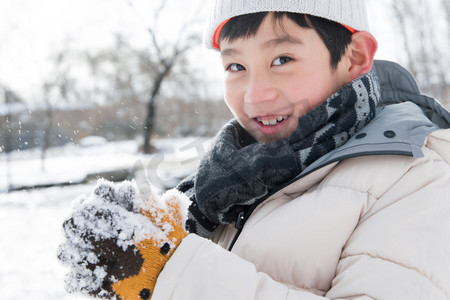 冬天小男孩摄影照片_在外面玩雪的小男孩
