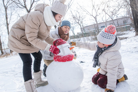 一家三口在雪地里堆雪人