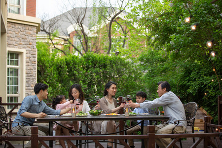 快乐大家庭在庭院里用餐