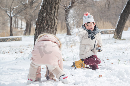 雪地里玩耍摄影照片_两个小朋友在雪地里玩耍