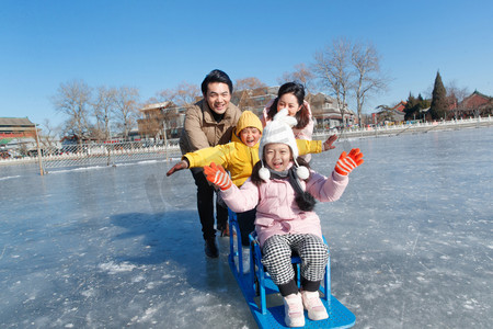 都市家庭摄影照片_快乐的一家四口坐冰车玩耍