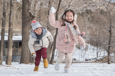 小朋友做游戏摄影照片_两个小朋友在雪地里玩耍