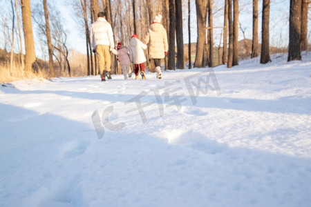 快乐家庭在雪地里散步