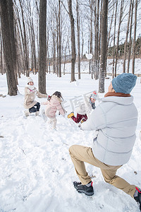 冬天打雪仗摄影照片_雪地里打雪仗的一家人