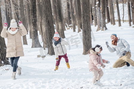 冬天雪景打雪仗摄影照片_雪地里打雪仗的快乐家庭