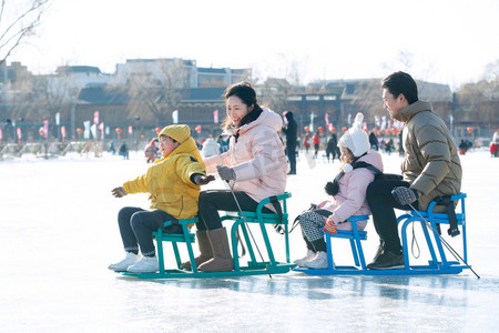 冬季衣服摄影照片_快乐的一家人坐冰车玩耍