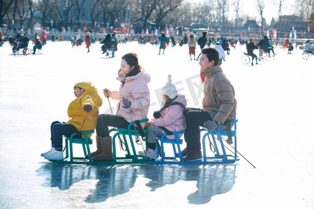 衣服城市摄影照片_快乐的一家人坐冰车玩耍