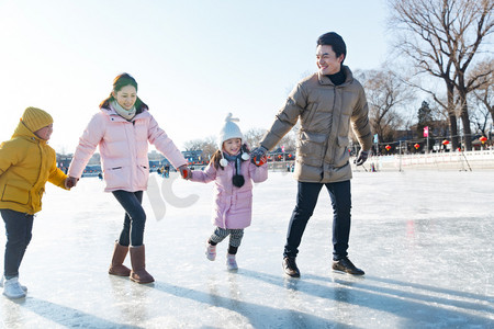 都市家庭摄影照片_手牵手滑冰的快乐家庭