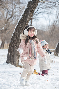 小朋友做游戏摄影照片_两个小朋友在雪地里玩耍