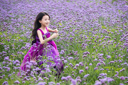 丝质裙子摄影照片_快乐的小女孩在花海里奔跑