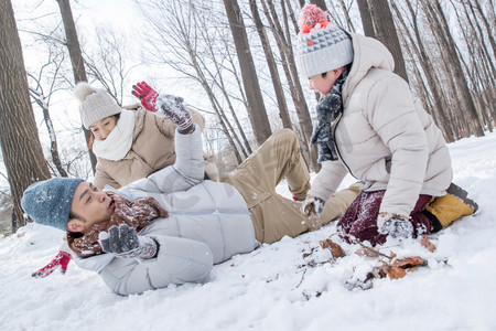 冬天雪景打雪仗摄影照片_打雪仗的快乐家庭