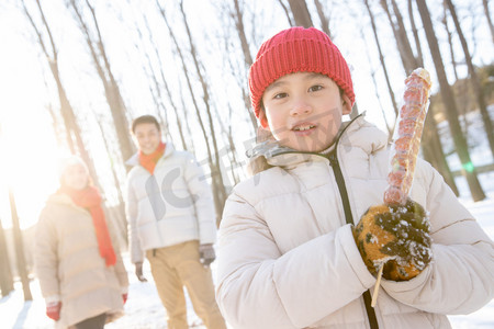 雪地上小男孩拿着糖葫芦