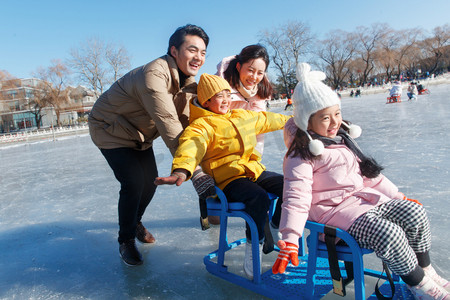 儿童衣服摄影照片_快乐的一家四口坐冰车玩耍