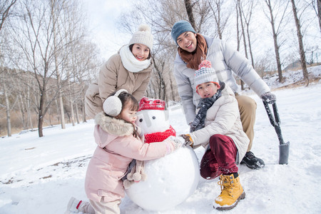 欢乐家庭在雪地里堆雪人