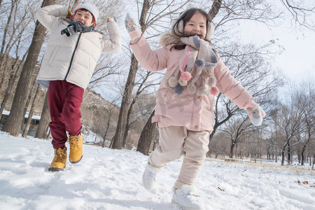 小朋友做游戏摄影照片_两个小朋友在雪地里玩耍