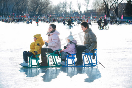 快乐的一家人坐冰车玩耍