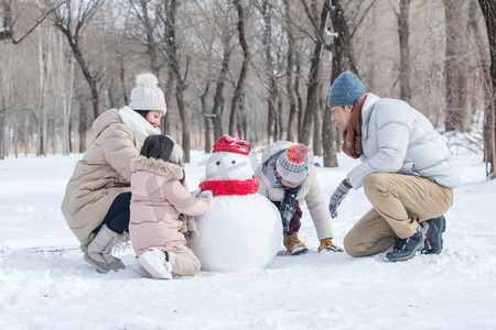 欢乐家庭在雪地里堆雪人