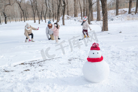 雪地里玩耍摄影照片_快乐的一家人在雪地里玩耍