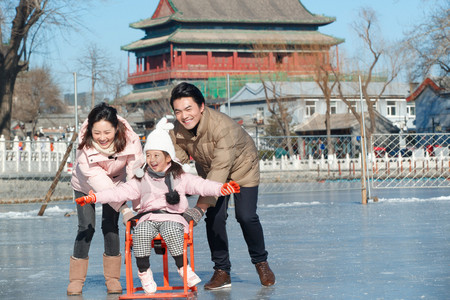 都市家庭摄影照片_快乐的一家三口坐冰车玩耍