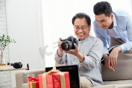 父亲节礼品摄影照片_快乐父子看照相机