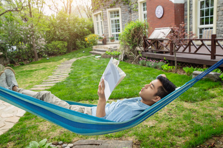 青年男人在院子里看书