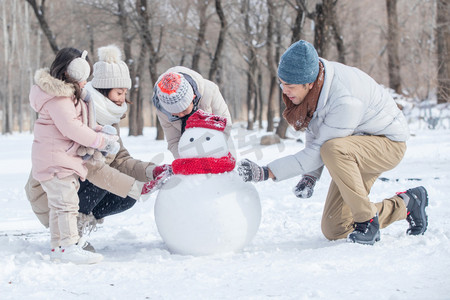 欢乐家庭在雪地里堆雪人