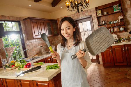 青年女人在厨房里做饭