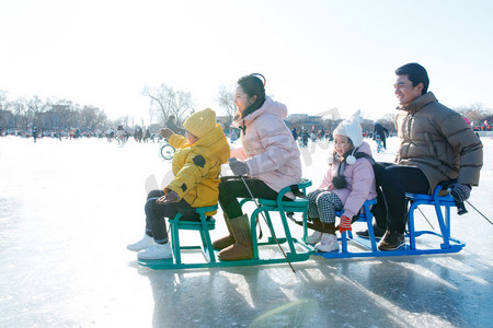 快乐的一家人坐冰车玩耍