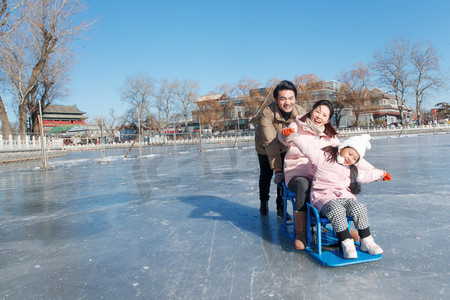 都市家庭摄影照片_快乐的一家三口坐冰车玩耍