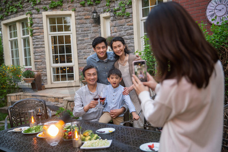 五个人摄影照片_快乐大家庭在庭院里用餐