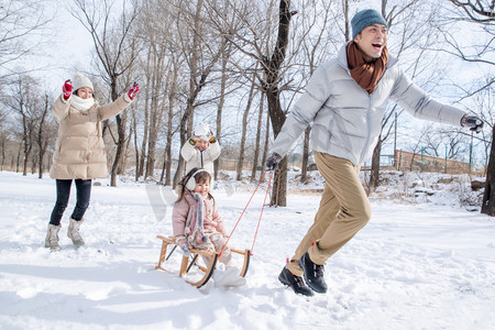 欢乐家庭在雪地上玩雪橇