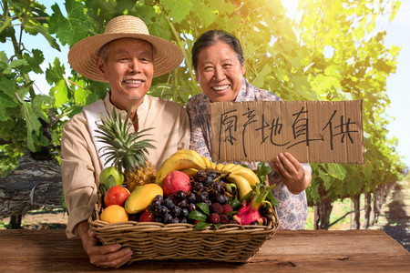 果农摄影照片_农民夫妇出示自家水果