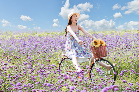 在花海里骑自行车的青年女人
