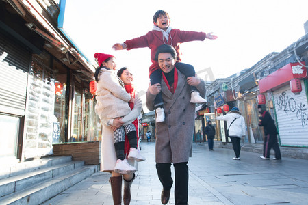 老北京胡同摄影照片_青年夫妇带着孩子逛街购物