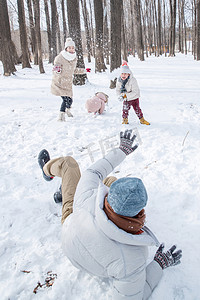 冬天雪景打雪仗摄影照片_雪地里打雪仗的快乐家庭