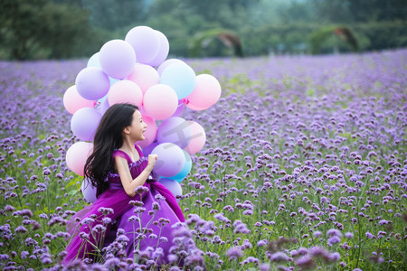 可爱奔跑摄影照片_拿着气球的小女孩在花海里奔跑
