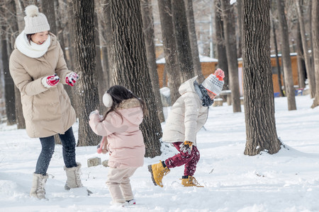 年轻妈妈和孩子们在雪地里玩耍