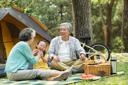 老年夫妇微笑摄影照片_老年夫妇带着孙女在公园里郊游