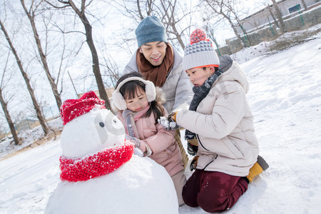 爸爸和孩子们推雪人