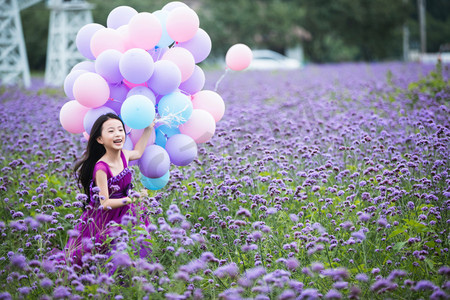 唯美花海摄影照片_拿着气球的小女孩在花海里奔跑