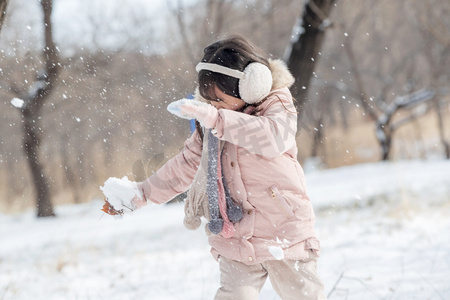 冬天树林摄影照片_快乐的小女孩在雪地里玩耍