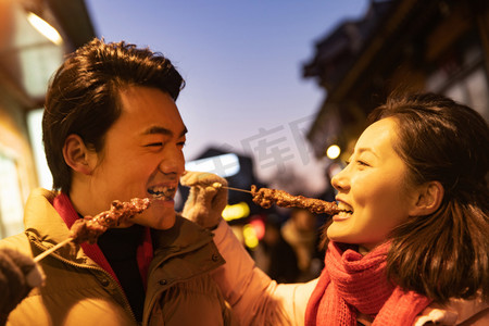 厚摄影照片_青年夫妇逛街吃羊肉串