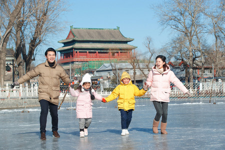 都市家庭摄影照片_手牵手滑冰的快乐家庭