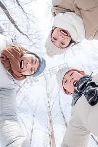 雪地里玩耍摄影照片_在雪地里玩耍的快乐家庭