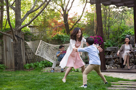 安全和谐摄影照片_快乐家庭在庭院里玩耍