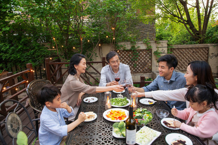 老年人用餐摄影照片_快乐大家庭在庭院里用餐