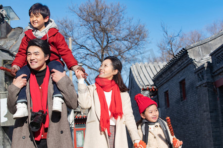 老北京糖葫芦摄影照片_青年夫妇带着孩子逛街购物