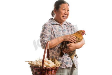 鸡和鸡蛋摄影照片_农民拿着鸡和鸡蛋